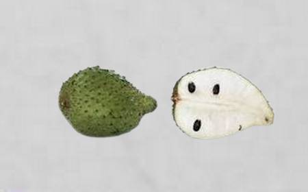 Corossol entier et coupé en deux, montrant sa peau verte épineuse et sa chair blanche avec des graines noires