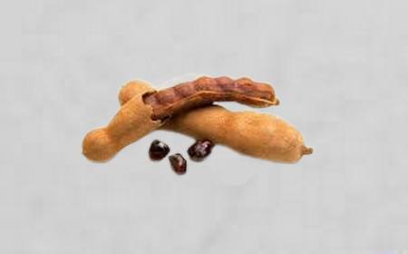 Gousses de tamarin entières et ouvertes montrant la pulpe